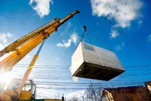 A crane on a construction site carries a freight box. Learn more about how a Jersey City crane accident lawyer can help you today.