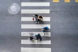 a-group-of-five-people-cross-a-crosswalk-aerial-view
