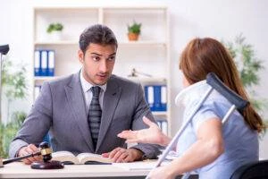 An injured woman with a crutch and a neck brace speaking to an experienced bus accident lawyer in Edwardsville about her legal options.