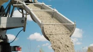 A concrete truck unloading concrete through the chute. Heavy concrete makes concrete truck accidents more dangerous than other crashes.