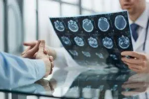 A doctor discussing a brain scan printout with a patient.
