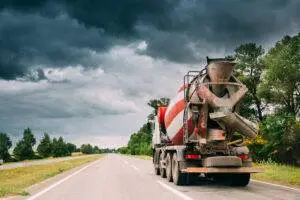 A concrete mixer truck driving down a highway. Drivers must take care to avoid concrete truck accidents.