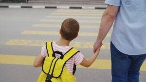 A young student crosses a Mt. Vernon pedestrian walkway with a parent.