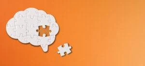 A jigsaw puzzle of a brain with one piece missing.