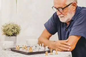 Elderly man plays chess after brain damage case.