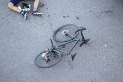 A fallen bicyclist on the roadway. Get help after your bicycle accident by contacting Morelli Law and our team of bicycle accident lawyers.