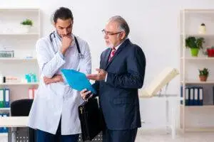 a mature male lawyer talking to a young male doctor about a defective medical device