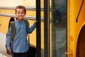 A boy getting on a school bus. Find out what to do if your child was injured in a school bus accident.