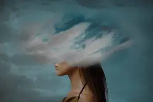 Woman’s head hidden by white cloud signifying brain damage.