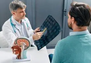 A doctor and patient looking at brain scans. You can build a claim for compensation with an O’Fallon brain damage lawyer.