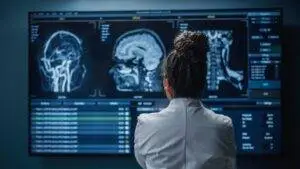 A doctor looking at brain scans. Discuss your legal situation now with a St. Louis brain damage lawyer.