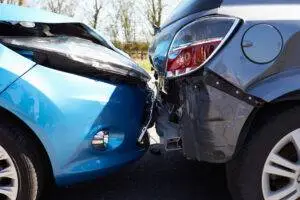 A close-up of front-end vehicular damage after a car accident.