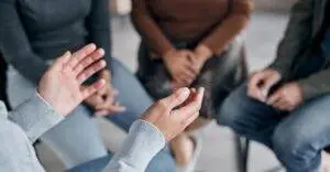 A person’s hands in conversation of a support group.