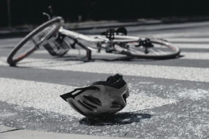 Bike helmet and bike laying down on cross walk.