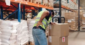 An employee in a warehouse bends over and grips his back in pain. What’s the average Workers’ Comp settlement for a back injury?