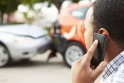 A man on the phone with a Santa Ana car accident lawyer after a collision.