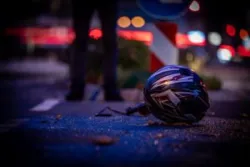 A motorcycle helmet lies on the road after a collision. A motorcycle accident lawyer in Covina will help you hold the at-fault party accountable.