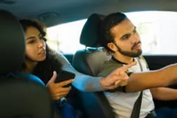 A woman giving directions during a Lyft ride. You can hire a Riverside Lyft accident lawyer for help after a collision.