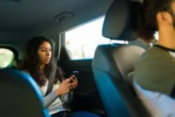 A woman taking a ride in an Uber. In the event of a crash, you can hire a San Diego Uber accident lawyer.