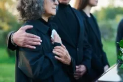 An elderly couple grieves at the funeral of a loved one. A San Jose wrongful death lawyer can help you in this tough time.