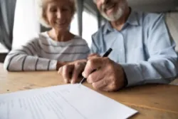 Personal injury victim signing for their settlement. Find out what the average settlement is for a personal injury claim.