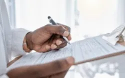 A man with a clipboard wonders, “How do I file an insurance claim against another driver?”