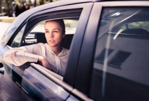 A concerned woman in the backseat of a car wondering what she should do if she’s a passenger in a car accident.