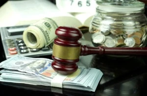 A gavel surrounded by money and a calculator as an illustration of legal damages such as special damages and general damages.