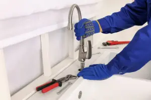 Technician Repairing Leaky Kitchen Faucet