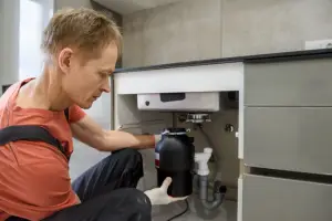 Man Removing A Garbage Disposal