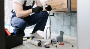 plumber using wrench to repair pipe