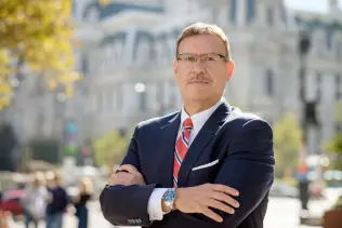 Portrait photo of Rand Spear Accident Attorney with arms crossed in front of Philadelphia City Hall