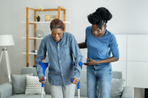 black nurse helping black patient walk