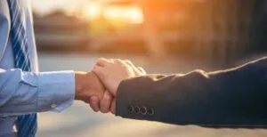 client and lawyer shaking hands at sunset