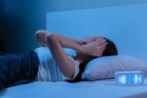 sad woman who can’t sleep with hands on her face