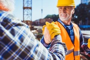 Construction workers shaking hands on a job site