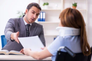 Lawyer sits at desk with injured client and explains difference between Jones Act vs. USL&H.