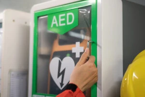 A person accessing an AED. Your lawyer can explain if a business can be sued for misusing or not having an AED.