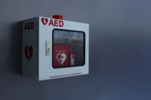 An AED device hanging on the wall. A lawyer can explain what evidence is needed in a defibrillator lawsuit.