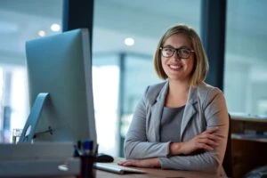 A truck accident lawyer in front of her computer with her arms crossed.