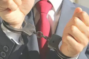 businessman in suit wearing handcuffs