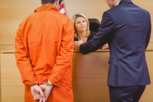 lawyer with defendant speaking to judge in court