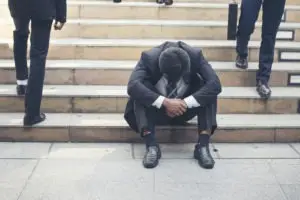upset man sitting on steps of courthouse