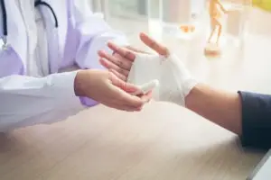 a doctor wrapping a burn on the hand of a patient