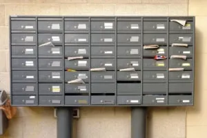 apartment mailboxes filled with various mail