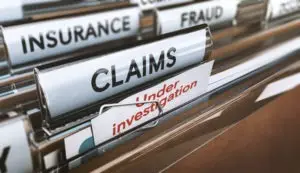 file folder tabs reading insurance fraud claims under investigation