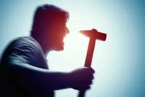 a man shouting and wielding a hammer