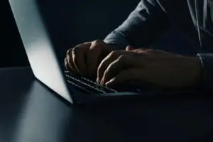 closeup of a man using a laptop in the dark