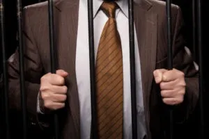 a man in a suit holding prison bars