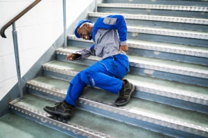 a worker grabbing his back after falling on the stairs